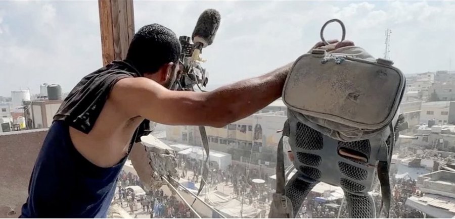 Image for the event titled: Civilian Abdullah Amer holds out Hussam Al-Masri's camera and vest after the first strike