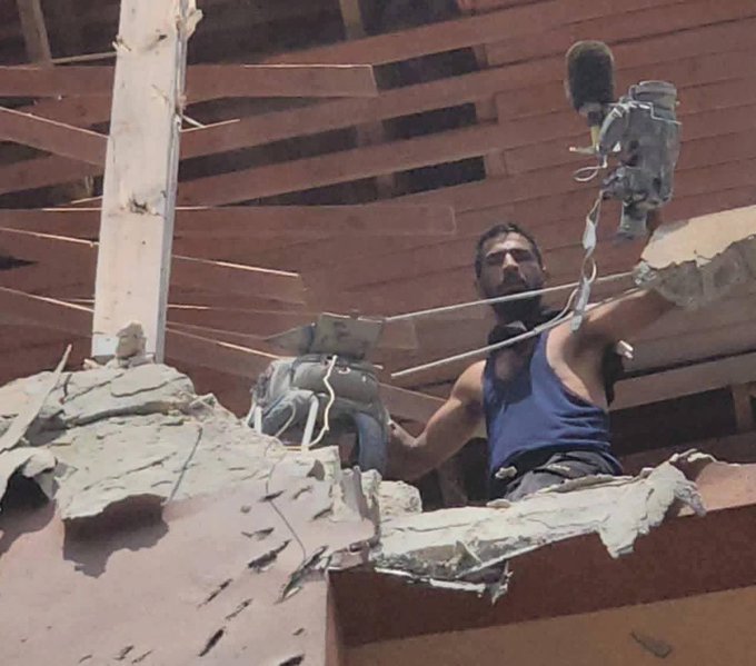 Image for the event titled: Civilian Abdullah Amer holds out Hussam Al-Masri's camera and vest after the first strike
