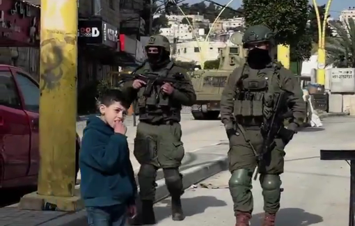 Thumbnail preview image for the video titled: Palestinian children playing face-to-face with heavily armed soldier sin the southern area of Hebron