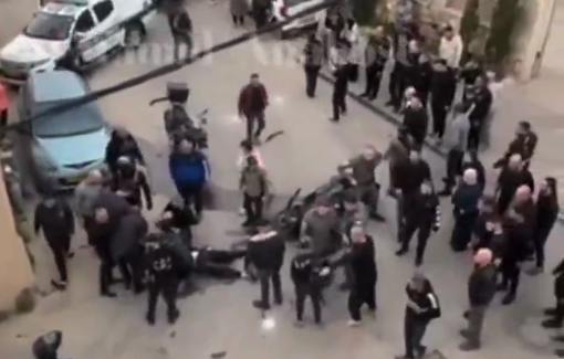 Thumbnail preview image for the video titled: After Border Police fatally shoot 18 y/o Arab motorcyclist during chase, an officer tosses a stun grenade at the crowd gathered near victim's body