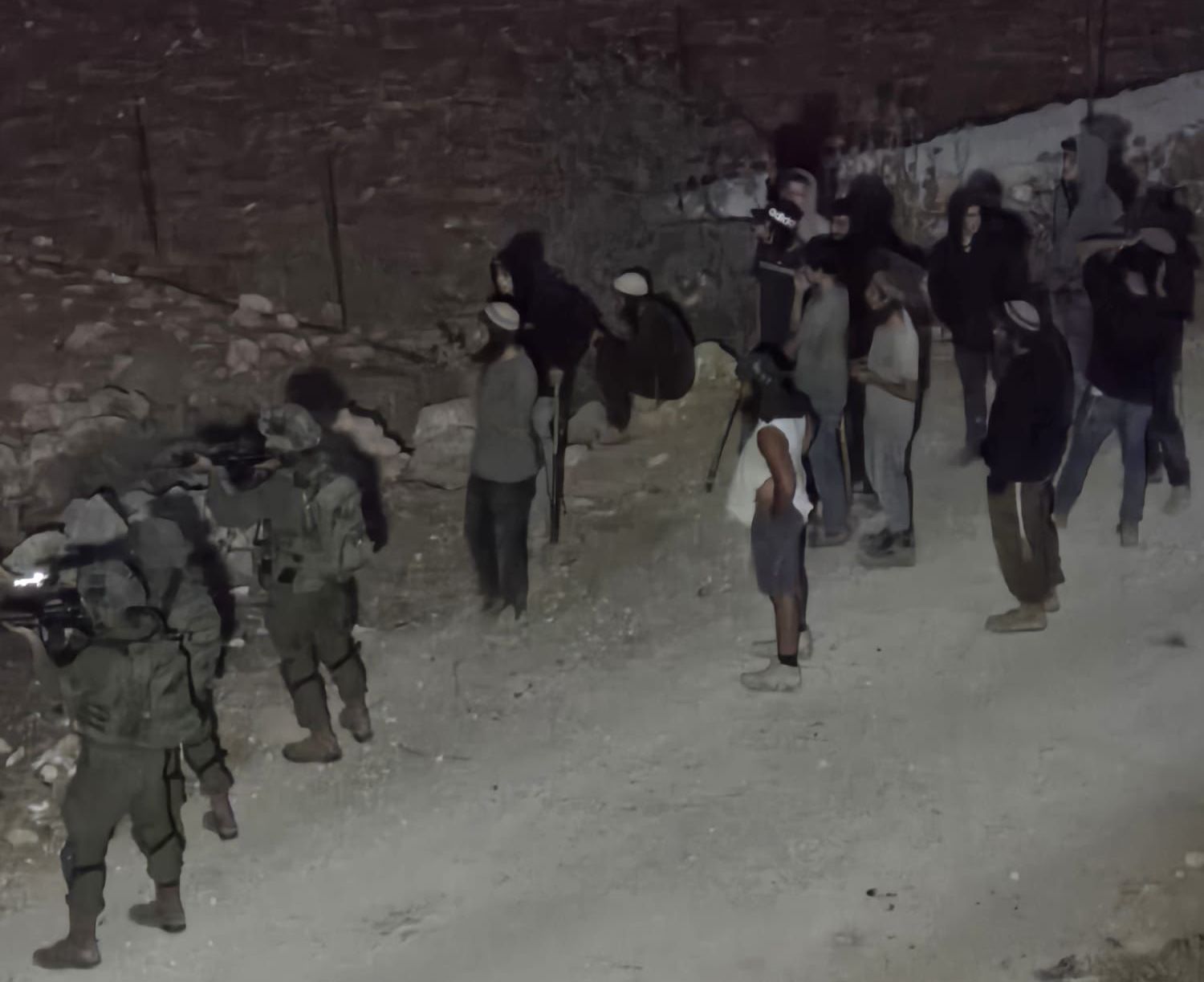 Thumbnail preview image for the video titled: In Al Mughayyir, Israeli soldiers shield Israeli settler terrorists after settlers attacked the village and shot three Palestinians