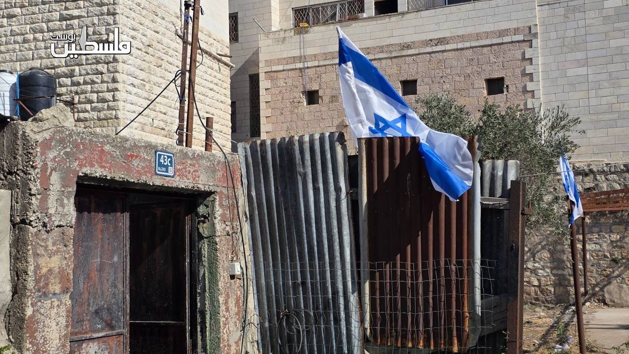 Thumbnail preview image for the video titled: Settlers raise Israeli flags on Palestinian land in Hebron’s Old City after seizing it under the protection of the soldiers