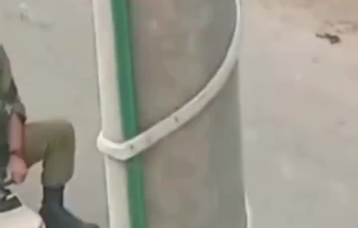 Thumbnail preview image for the video titled: An Israeli soldier seizes a small plastic toy car and sits on it during a raid in Far’un