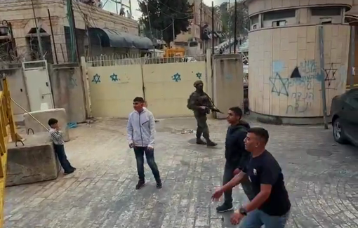 Thumbnail preview image for the video titled: Palestinian children played together in front of the Israeli-imposed iron gates at the entrance to Hebron's Old City