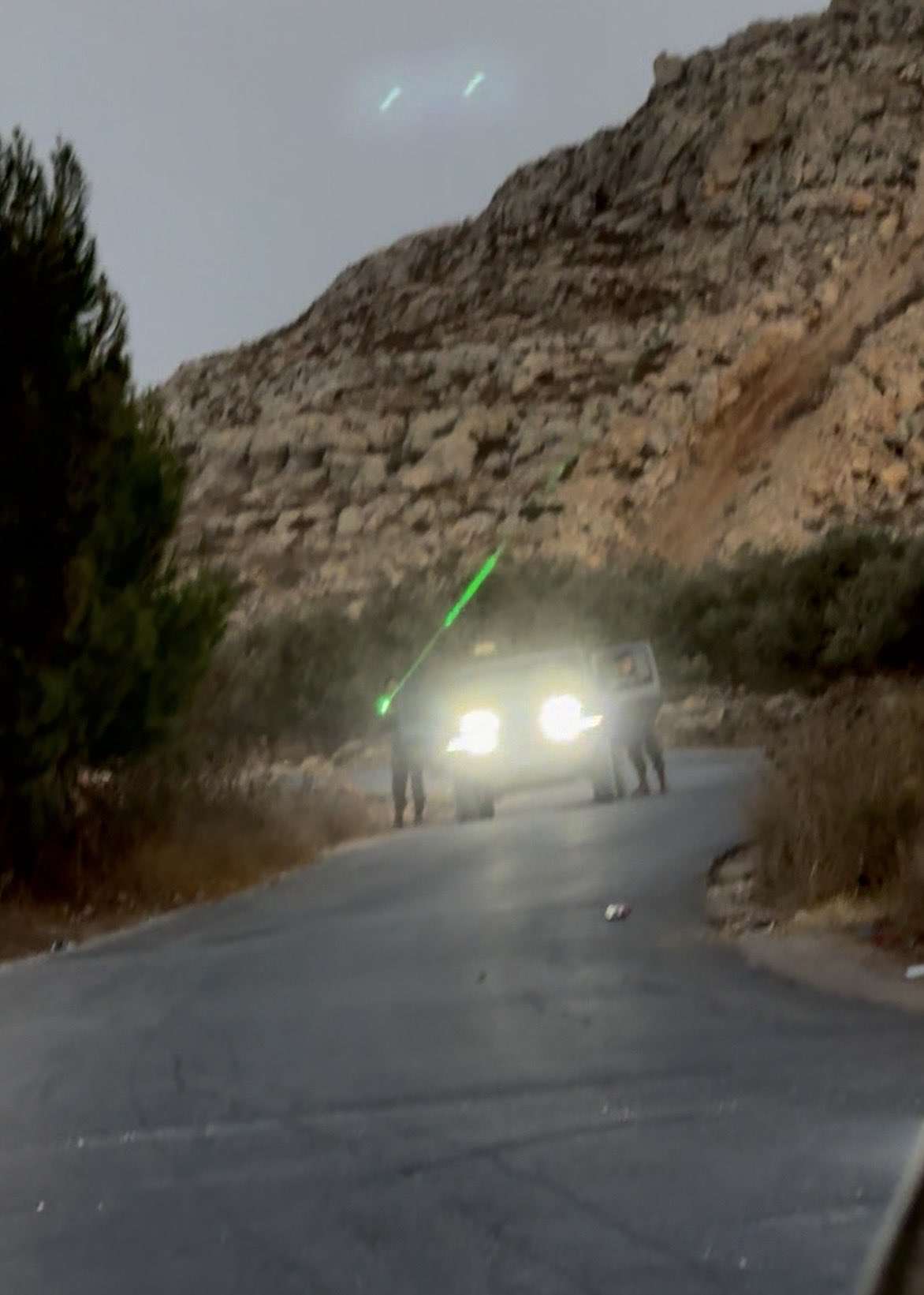 Thumbnail preview image for the video titled: Israeli soldiers driving by with a hand on a machine gun, right beside evacuated Palestinians praying on the side of the road